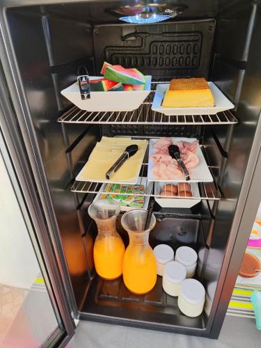 a refrigerator filled with lots of food and orange juice at B&B Chambre 1 Vila Alegria ESTOI in Estói