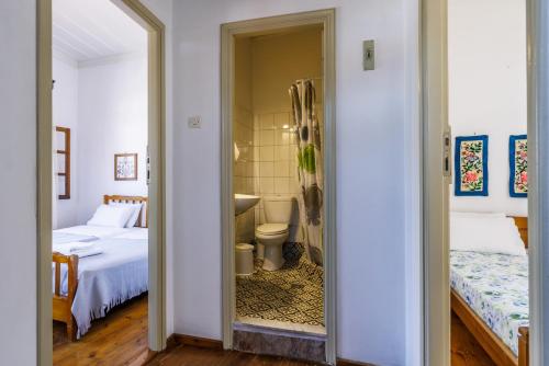 1 dormitorio con 2 camas y baño con aseo. en House Vasaki, en Skopelos Town