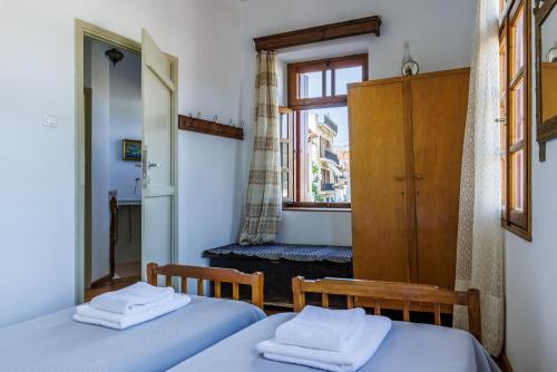 sypialnia z 2 łóżkami i oknem w obiekcie House Vasaki w mieście Skopelos