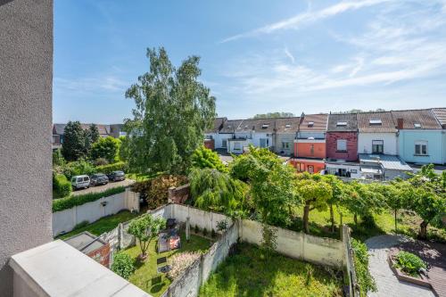 an apartment with a rooftop garden with trees and buildings at Le Petit Riad in Vilvoorde