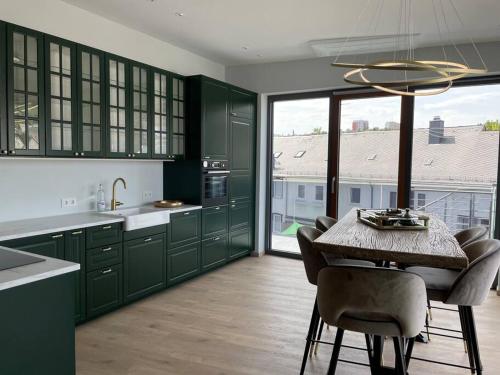 a kitchen with green cabinets and a table with chairs at Penthouse im Herzen von Herborn in Herborn