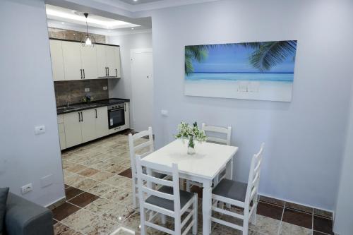 瓦利波約的住宿－Fishta apartments Q5 34，厨房以及带白色桌椅的用餐室。