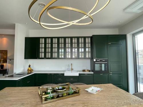 a kitchen with green cabinets and a large chandelier at Penthouse im Herzen von Herborn in Herborn