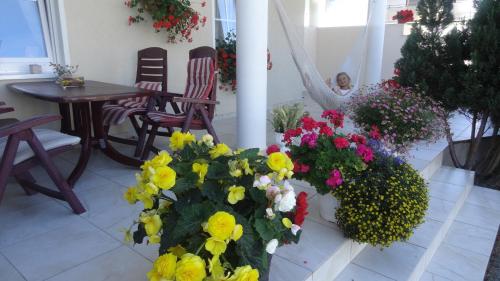 a woman is sitting in a room with flowers at Pensjonat Amor in Mielno
