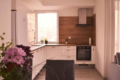 a kitchen with white cabinets and a window at Elegant Escape apartment I - City Centre in Bratislava