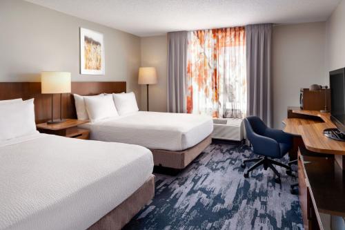 a hotel room with two beds and a desk at Fairfield Inn & Suites by Marriott Jacksonville in Jacksonville