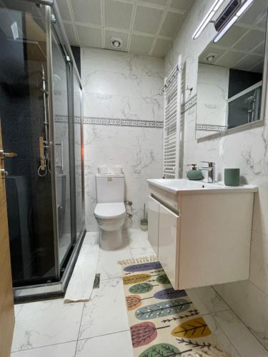 a bathroom with a toilet and a sink and a shower at Skopje Station Apartment in Skopje