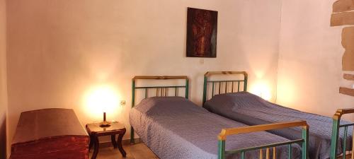 a bedroom with two beds and a table with a lamp at Irene's Guest House in Frés