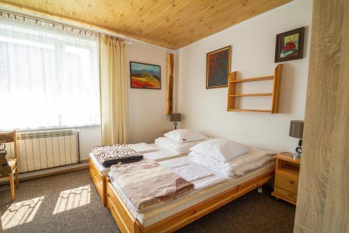 1 dormitorio con cama, ventana y ventana en Carynka, en Ustrzyki Górne