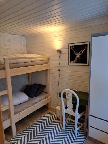 a room with two bunk beds and a chair at Guesthouse Nature Trails Sweden 