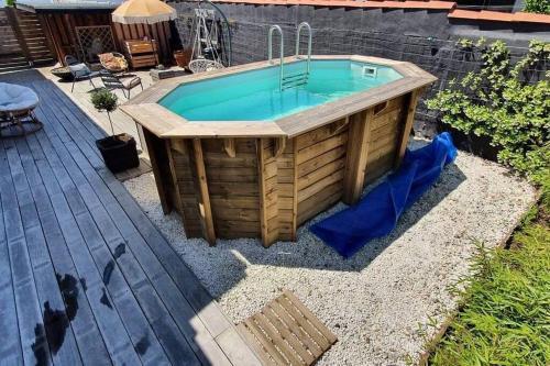 un bain à remous dans une arrière-cour avec une terrasse dans l'établissement Maison de ville avec piscine, à La Teste-de-Buch