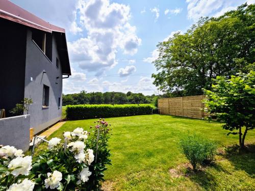 a garden with white flowers and a fence at Charming Cottage Novo Čiče in Novo Čiče