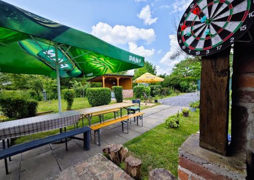 a group of benches with umbrellas and a dart board at Charming Cottage Novo Čiče in Novo Čiče
