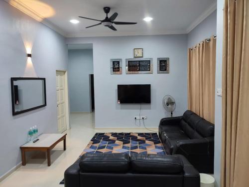 ein Wohnzimmer mit einem Sofa und einem Flachbild-TV in der Unterkunft Bella Homestay Perlis in Arau