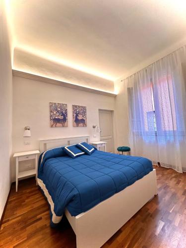 a bedroom with a large blue bed in a room at Casa Clementina in Pisa