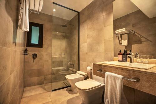 uma casa de banho com um chuveiro, um WC e um lavatório. em Posada Salentein em Los Árboles