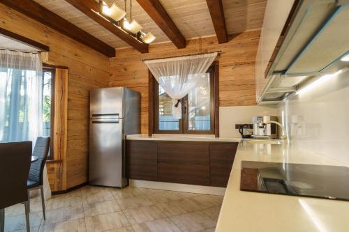 a kitchen with a stainless steel refrigerator and wooden walls at Dacha 9 in Voropayev