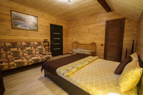 a bedroom with a bed and a couch in a cabin at Dacha 9 in Voropayev