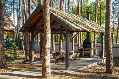 a wooden pavilion with a picnic table and a grill at Dacha 9 in Voropayev