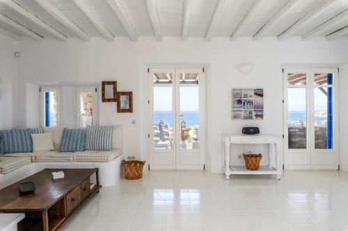 a white living room with a couch and a table at Salty Blè in Agios Ioannis Mykonos