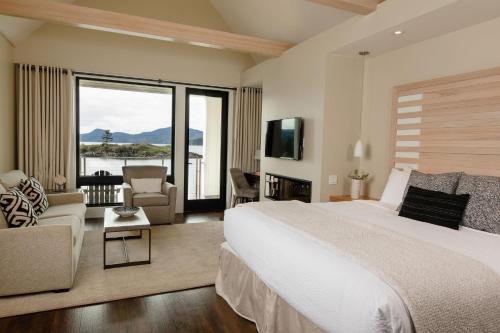 a bedroom with a large bed and a living room at Outlook Inn on Orcas Island in Eastsound