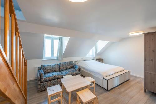ein Wohnzimmer mit einem Sofa und einem Bett in der Unterkunft M&F Sweet In Grey in Vilvoorde