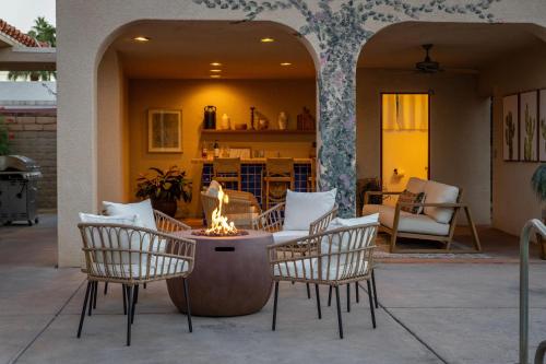 a group of chairs and a fire pit on a patio at Casa Del Lobo in Palm Springs