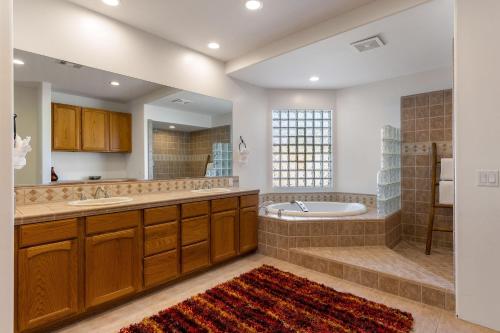 a large bathroom with a tub and a sink at Casa Del Lobo in Palm Springs