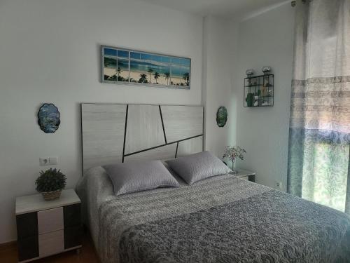 um quarto com uma cama e uma fotografia na parede em Apartamento La Urba em Roquetas de Mar