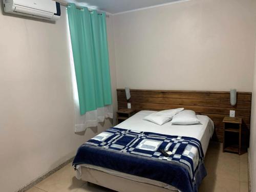 una camera con letto e finestra verde di BIG HOTEL a Osório