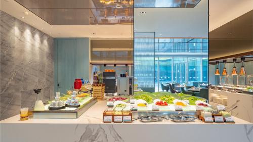 a buffet line with food on display in a building at Holiday Inn Changchun Oriental Plaza by IHG in Changchun