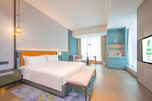 a bedroom with a large white bed and a tv at Holiday Inn Changchun Oriental Plaza by IHG in Changchun
