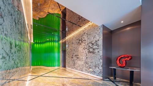 a room with a green wall and a red chair at Holiday Inn Changchun Oriental Plaza by IHG in Changchun
