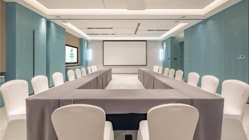 a conference room with a long table and white chairs at Holiday Inn Changchun Oriental Plaza by IHG in Changchun