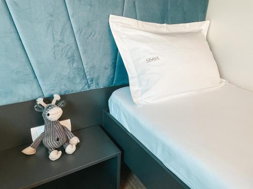 a small stuffed animal sitting on a nightstand next to a bed at SEAYA mobile home - Terra Park SpiritoS in Kolan
