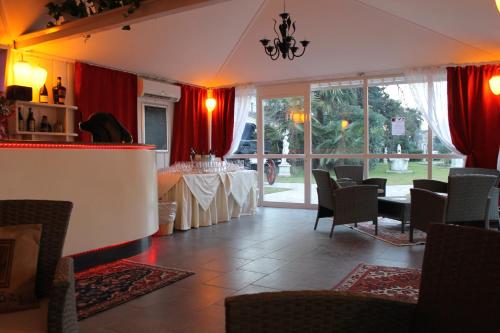 モリアーノ・ヴェーネトにあるホテル ヴィラ スタッキーのダイニングルーム(テーブル、赤いカーテン付)