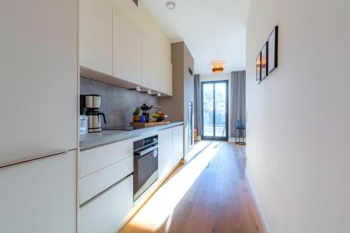 a kitchen with white cabinets and a wooden floor at Ferienwohnung Sonnenschein im Ostseebad Sellin in Ostseebad Sellin
