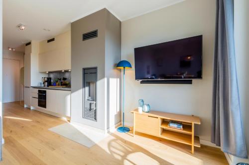 a living room with a table and a tv on a wall at Ferienwohnung Sonnenschein im Ostseebad Sellin in Ostseebad Sellin