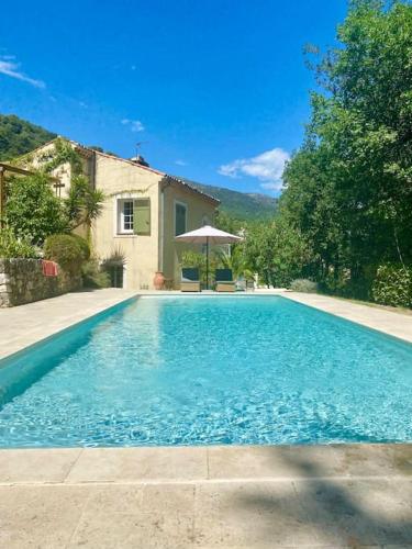 une piscine devant une maison dans l'établissement Villa dans écrin de verdure avec sa grande piscine, à Gattières