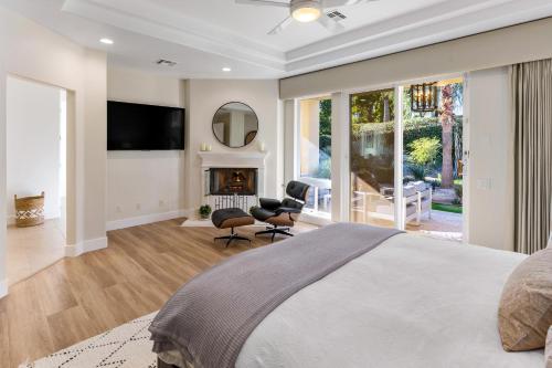 een slaapkamer met een groot bed en een open haard bij Mon Cheri Estate in Palm Springs