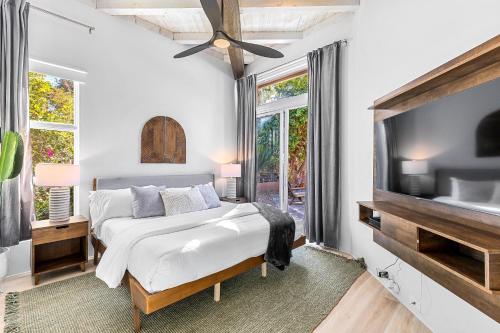 um quarto branco com uma cama e uma televisão em Camino Mountain Villa em Palm Springs