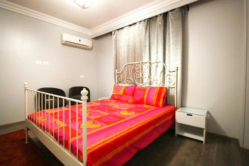 a bedroom with a white bed with a red comforter at Apple Candy property in Madinaty in Madīnat ash Shurūq
