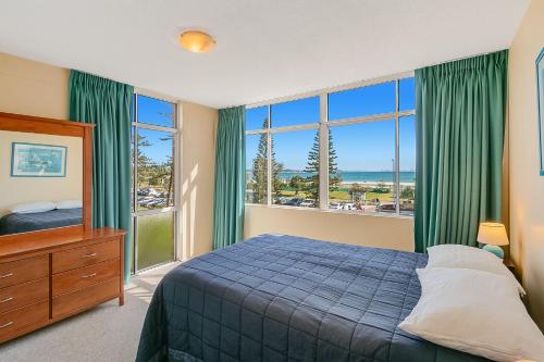 a bedroom with a bed and a large window at Beach Lodge Unit 9 in Gold Coast