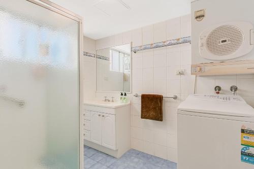 a white bathroom with a sink and a shower at Beach Lodge Unit 9 in Gold Coast