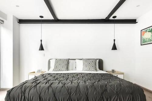 um quarto com uma cama preta e paredes brancas em Uppermost 3BR, Gym, Roofgarden. Socrates em Cidade do México