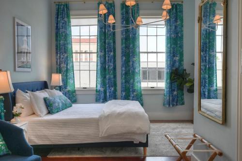 um quarto com uma cama com cortinas azuis e um espelho em Sugars INN Room #4 em Galveston