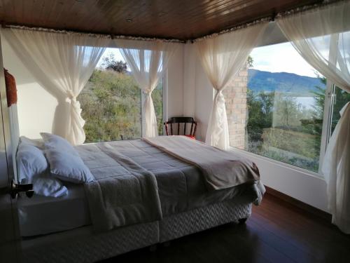 1 dormitorio con cama y ventana grande en Chalet_Laguna_Azul, en Aquitania