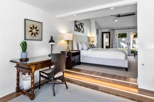 a bedroom with a bed and a desk with a chair at Lola Vista in Palm Springs