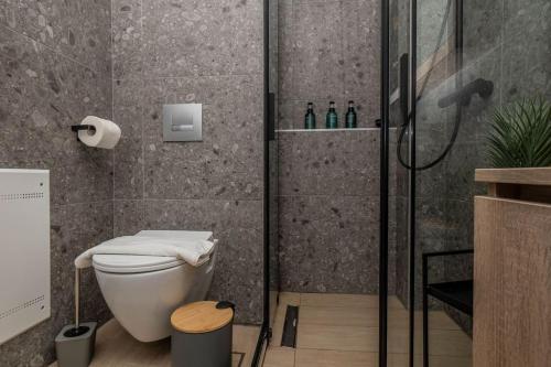 a bathroom with a toilet and a glass shower at 8 Blocks Apartments 4A in Alexandroupoli