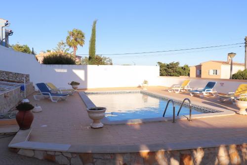 a swimming pool with lounge chairs and a swimming pool at Luxury Villa with ocean view in Luz